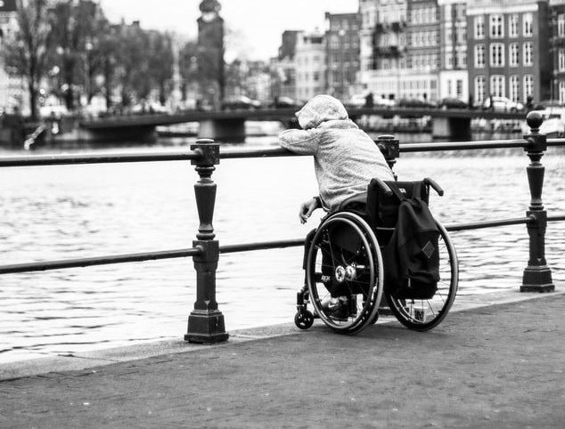 vulnerable adult in wheelchair looking out onto water on Christmas