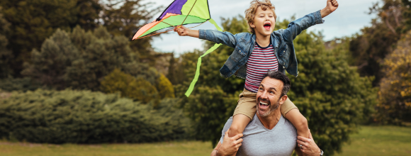 Father and young son playing together at a summer picnic